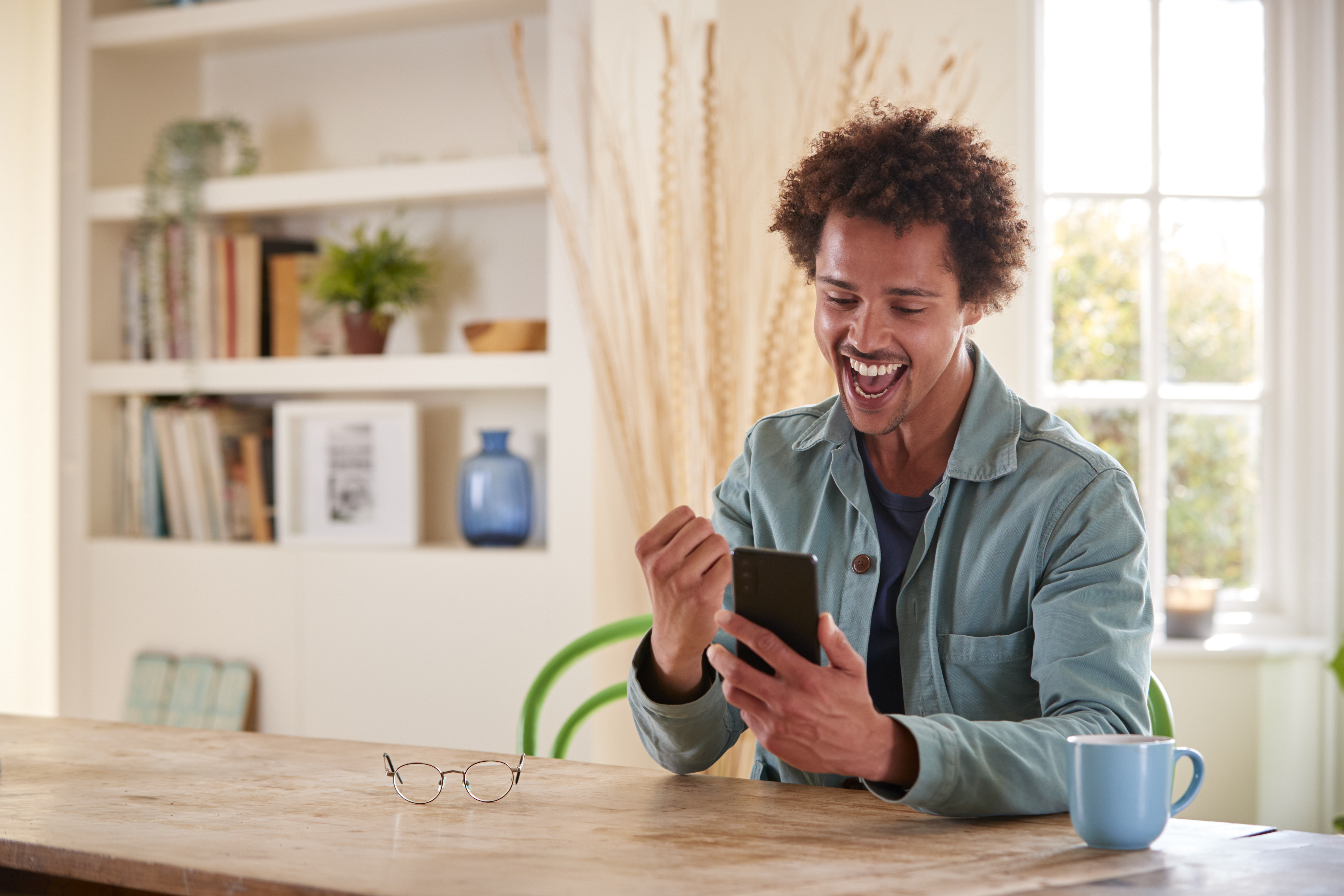 enthusiastic young man celebrates success at home 2026 03 10 03 16 26 utc