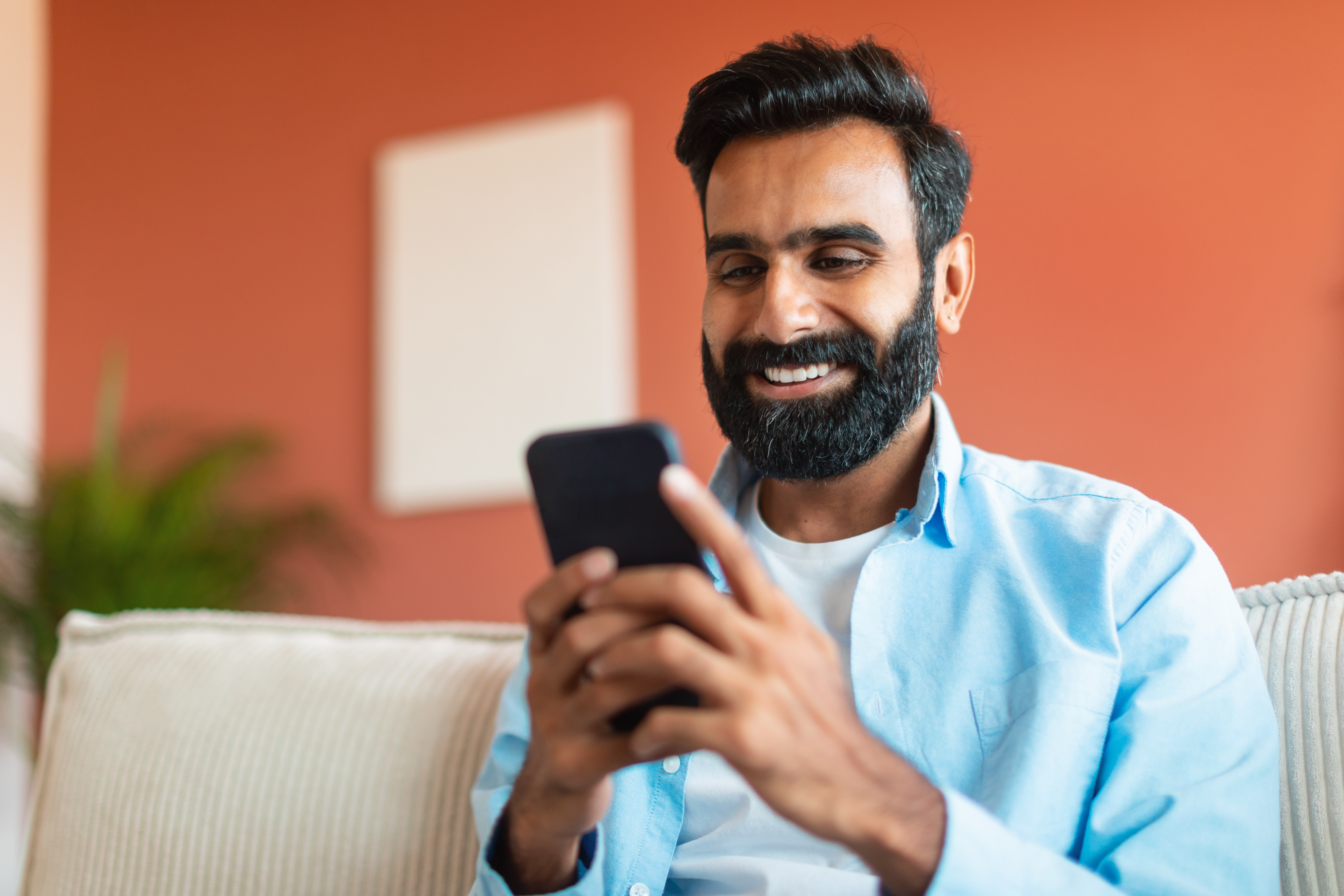 man smiling using mobile phone at home 2026 01 08 23 08 16 utc