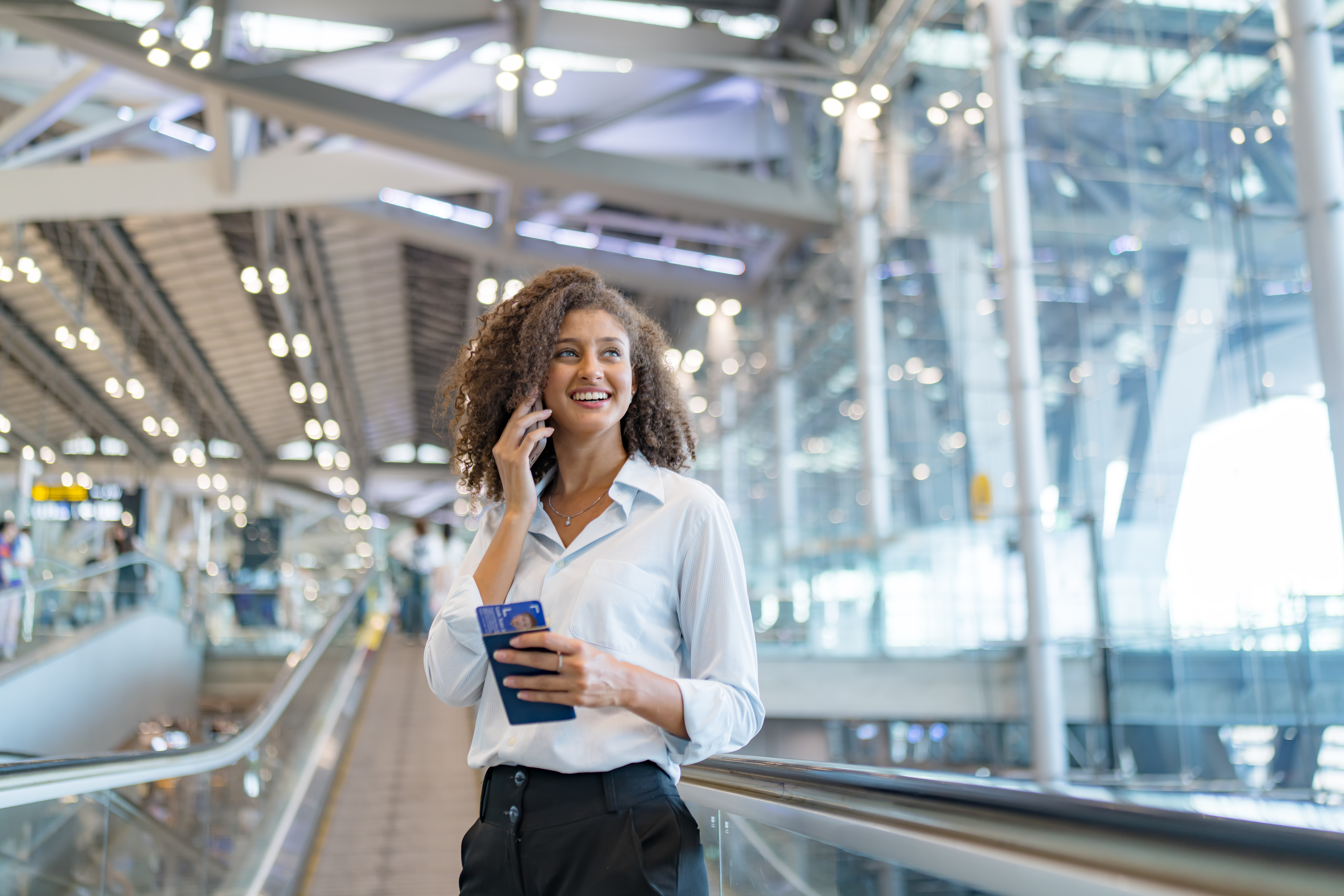smiling businesswoman on phone holding passport an 2026 04 20 16 46 11 utc