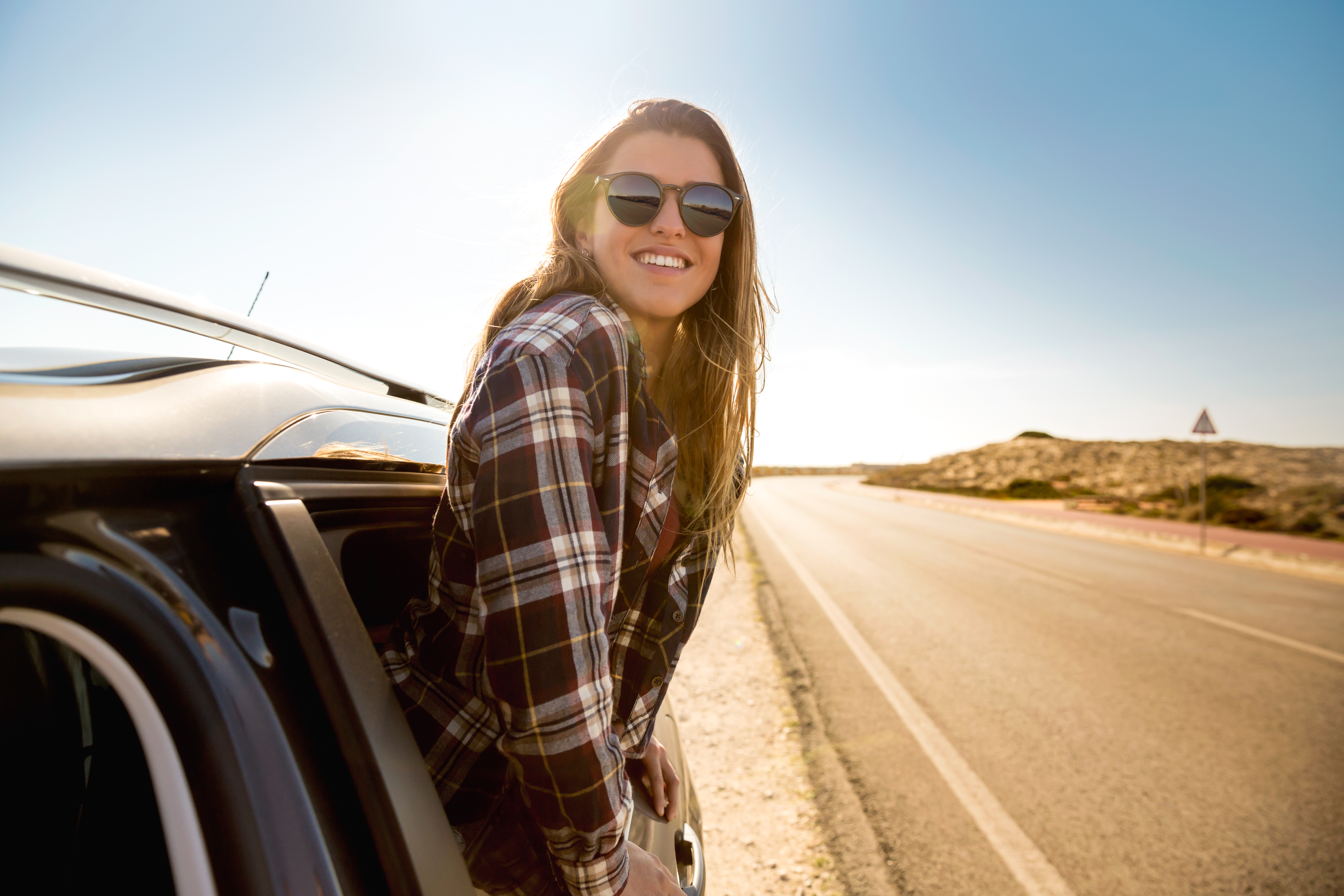 smiling woman on road trip on a sunny day 2026 01 06 10 39 31 utc