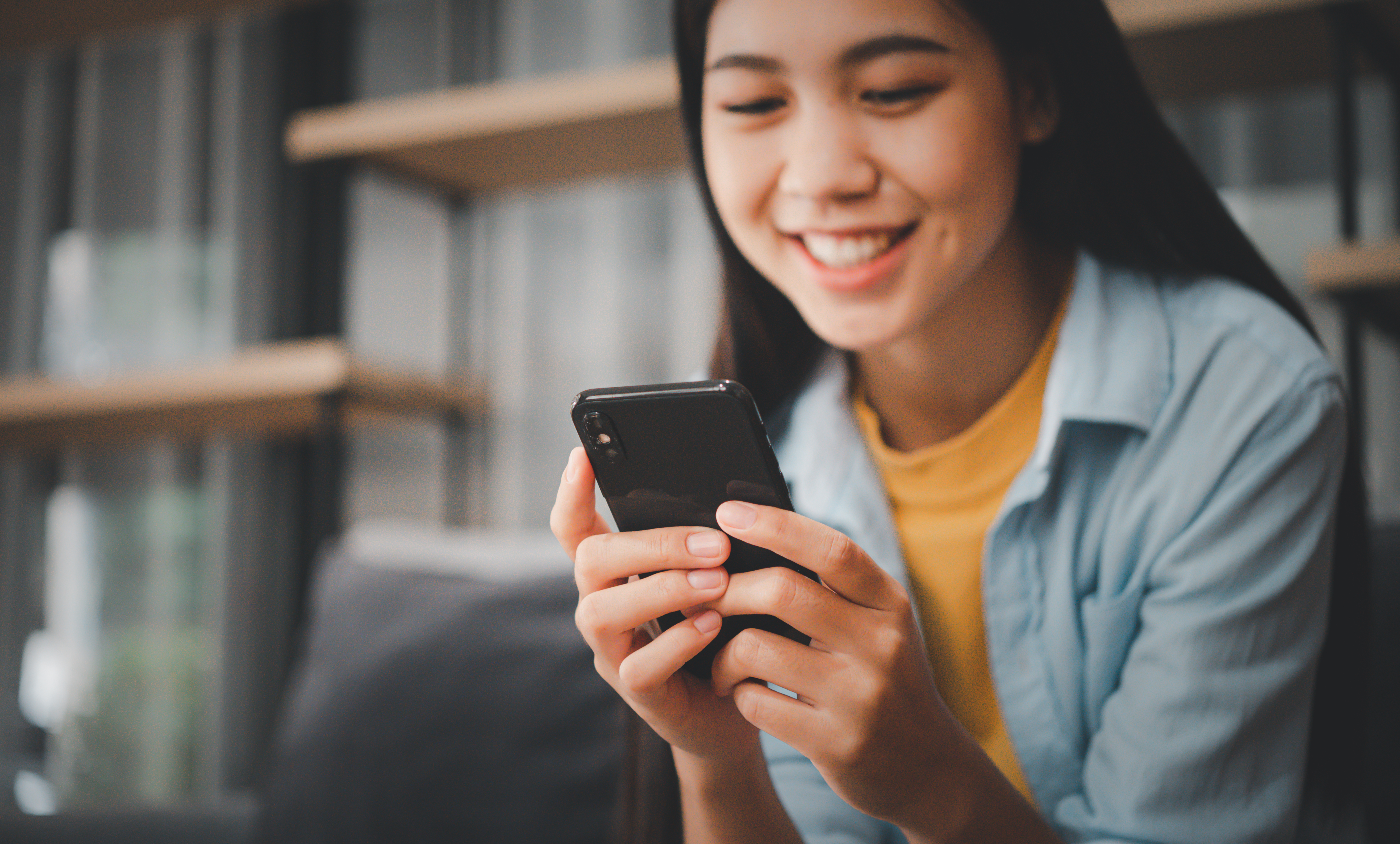smiling woman using a mobile phone indoors 2026 03 24 05 08 56 utc