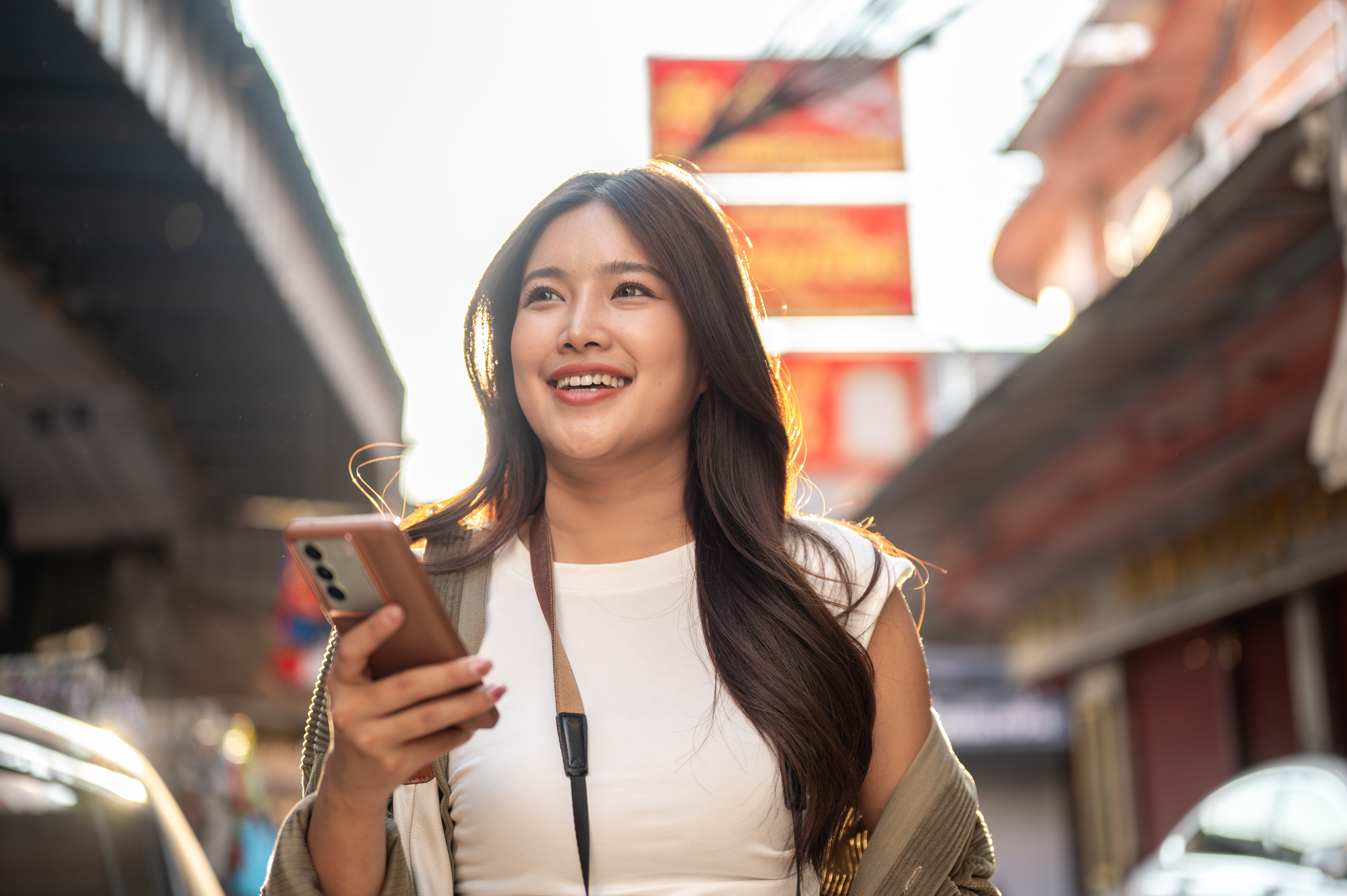 smiling asian woman holding phone while standing o 2026 04 07 17 55 09 utc