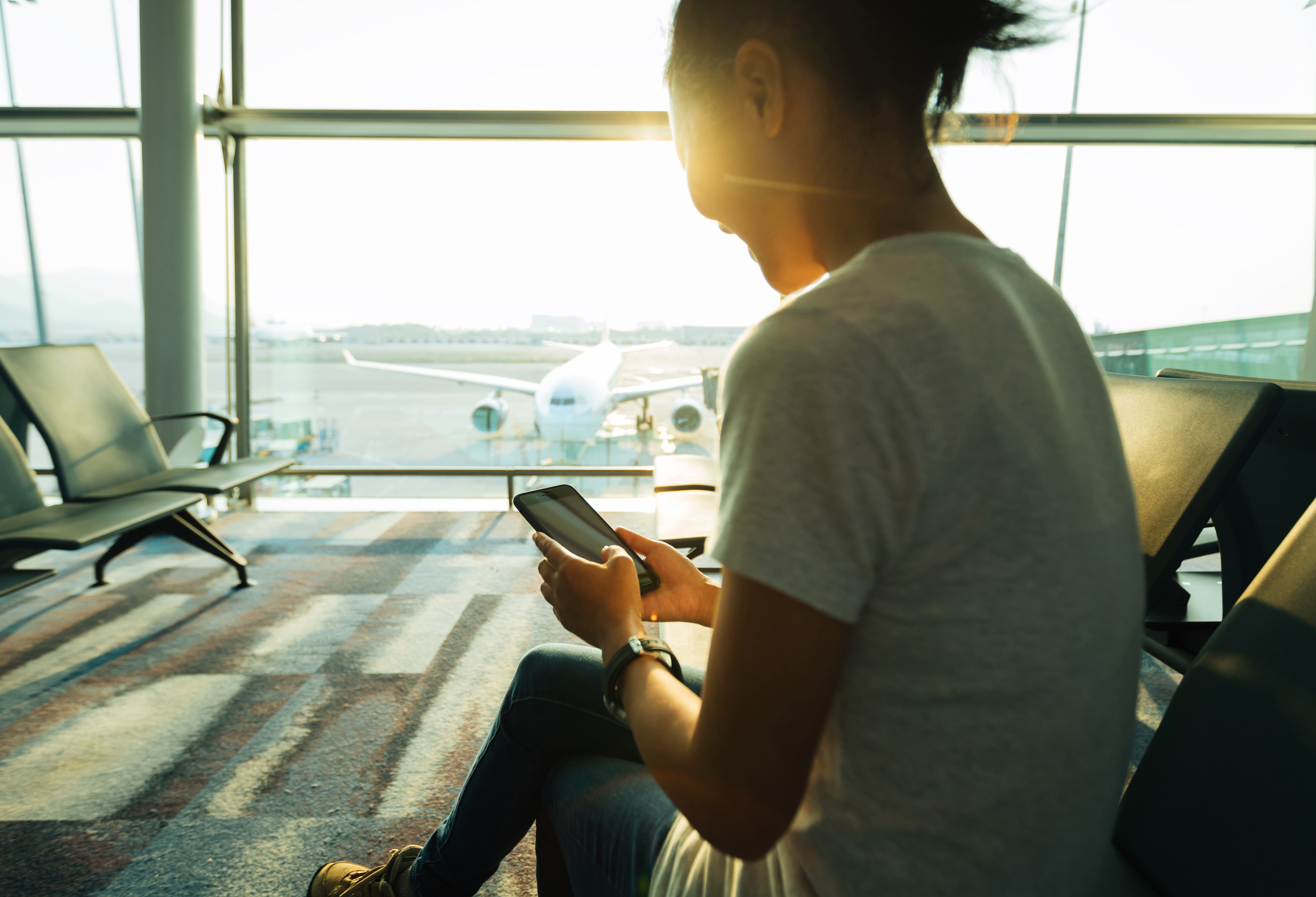 woman using cellphone in airport 2026 03 17 09 00 55 utc