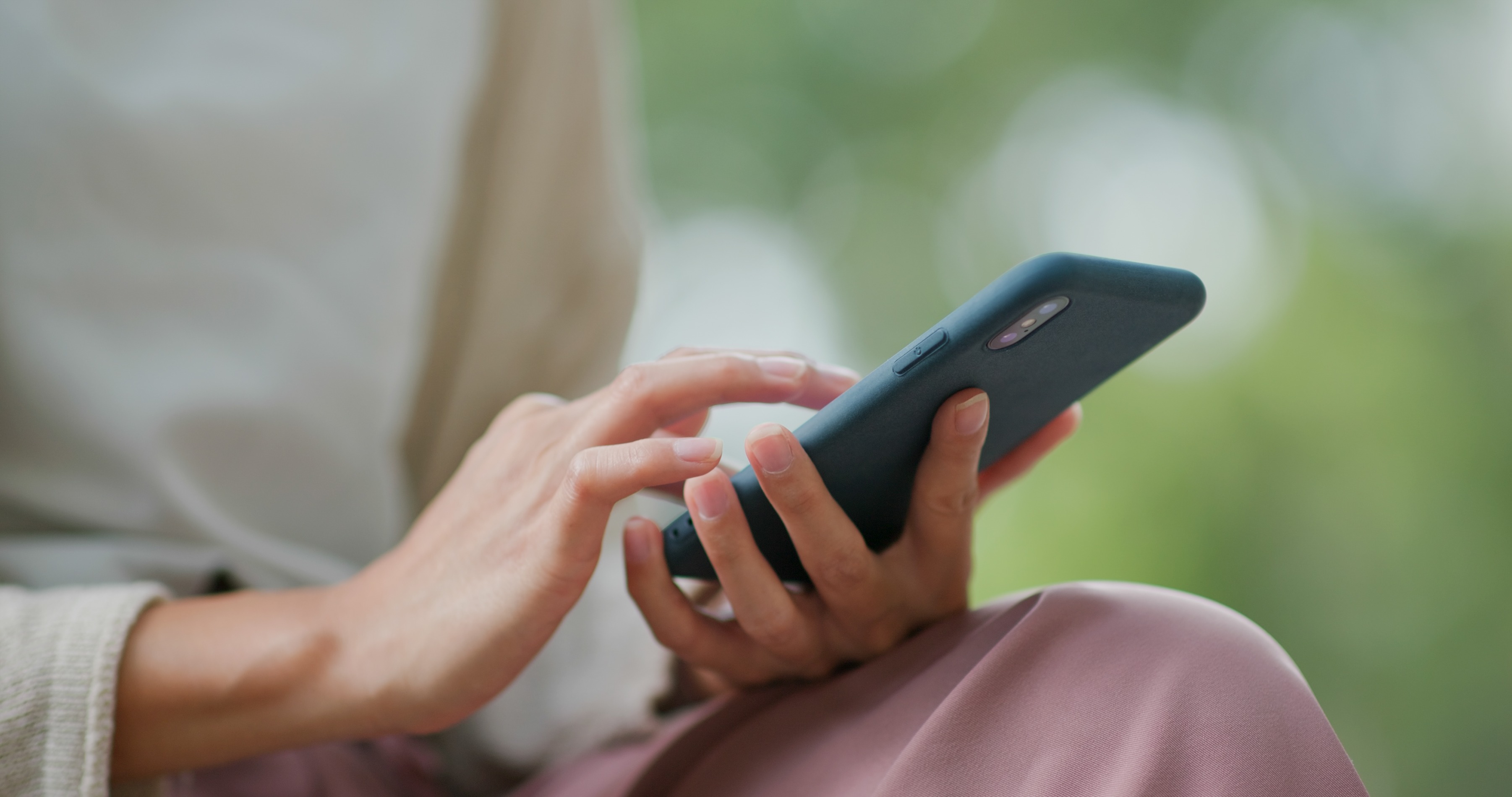 woman using smartphone in outdoor green setting 2026 03 24 23 23 54 utc