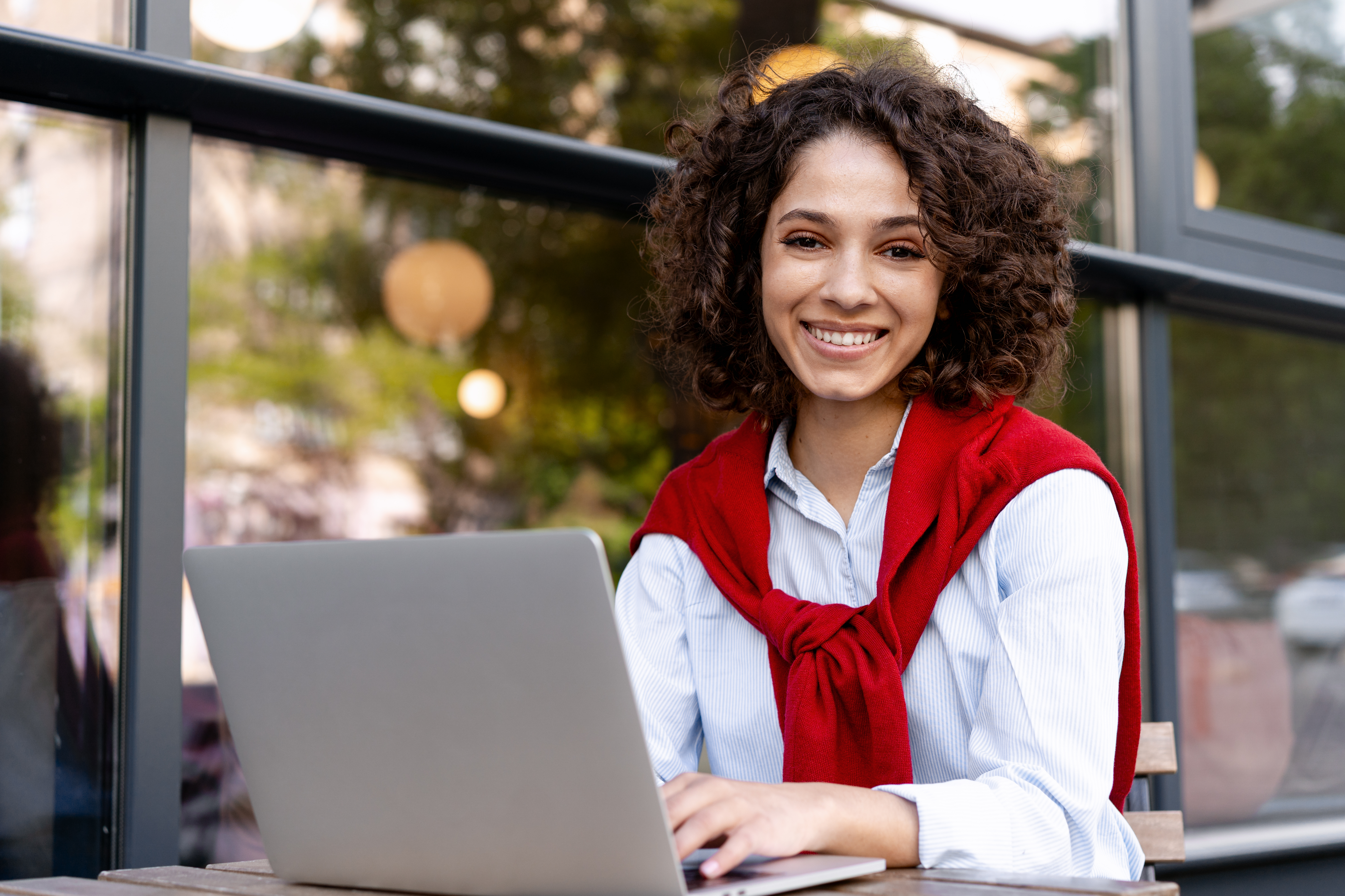 smiling young woman working on laptop outdoors 2026 01 11 11 11 00 utc