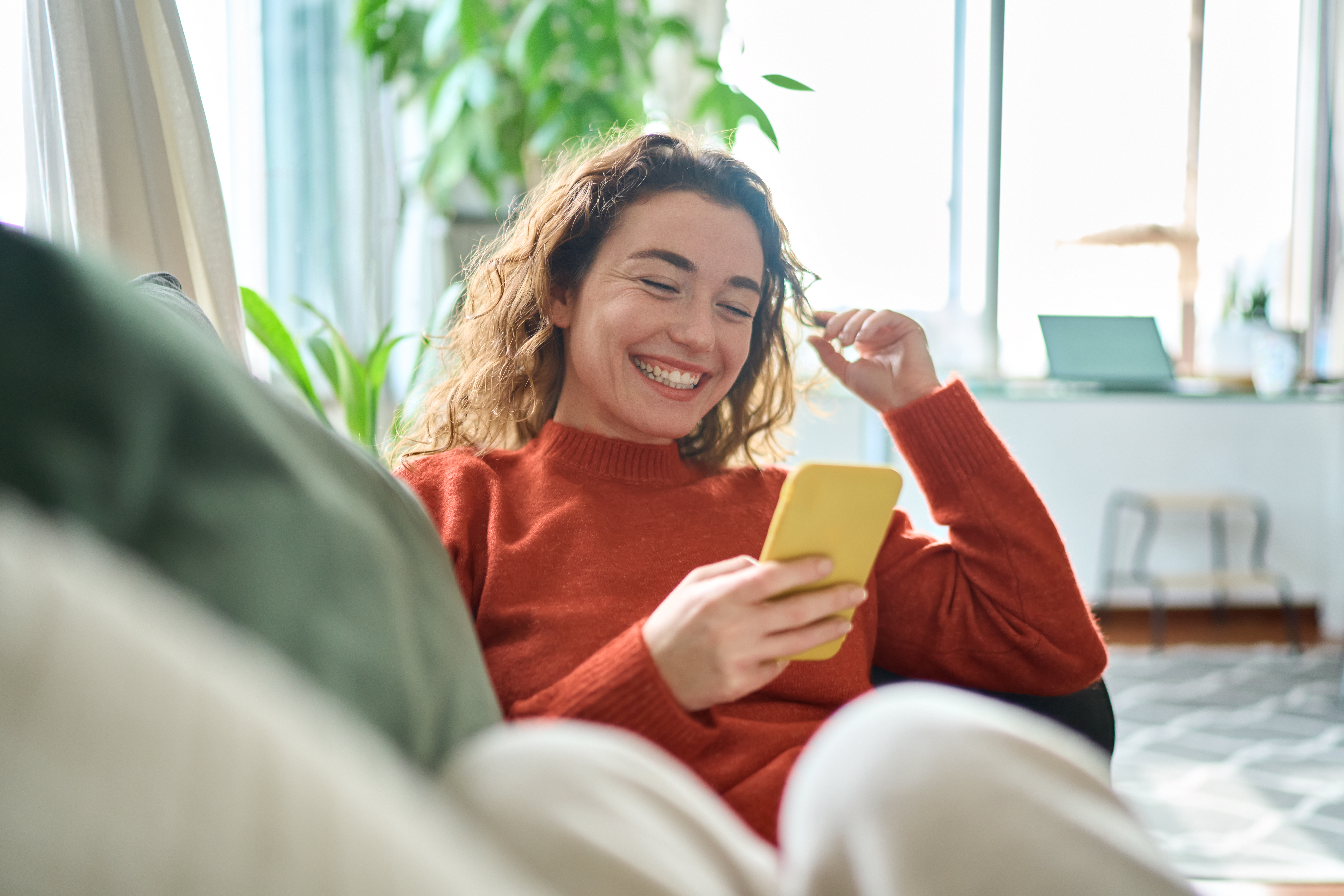 smiling woman using phone in bright home interior 2026 09 21 18 23 11 utc