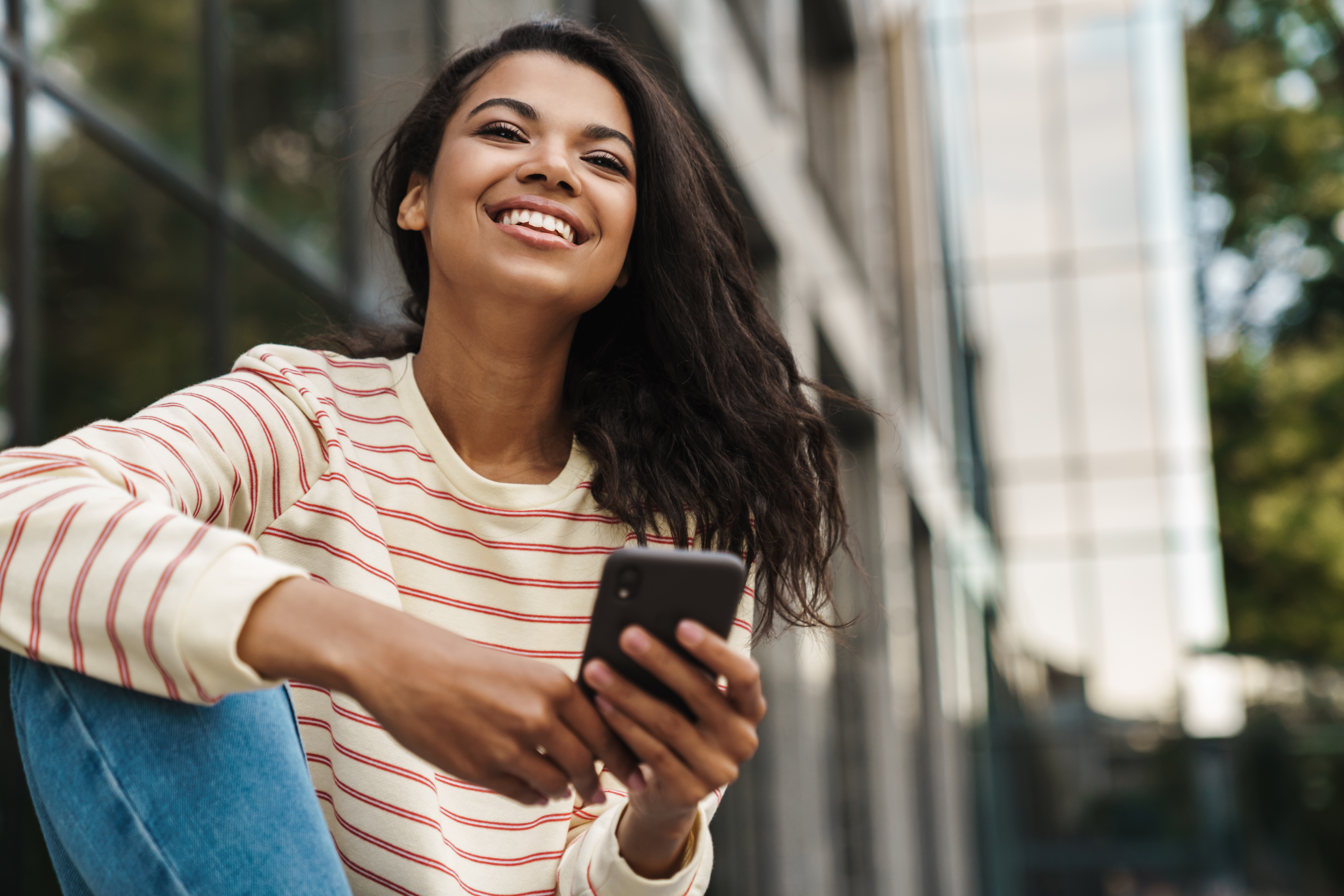 smiling woman with mobile phone leaning against bu 2026 09 22 00 27 57 utc